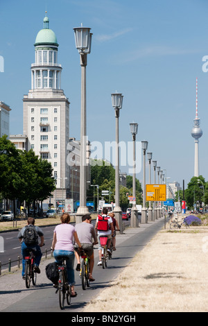 View along famous Karl Marx Allee towards Frankfurter Tor and television tower or Fernsehturm at Alexanderplatz in East Berlin Stock Photo