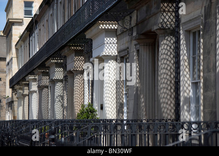 Shadows on the pillars of a row of buildings in the centre of Edinburgh, Scotland, caused by the decorative ironwork balconies. Stock Photo