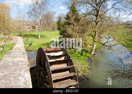 The waterwheel from the old corn mill beside the River Coln in the Cotswold village of Quenington, Gloucestershire Stock Photo