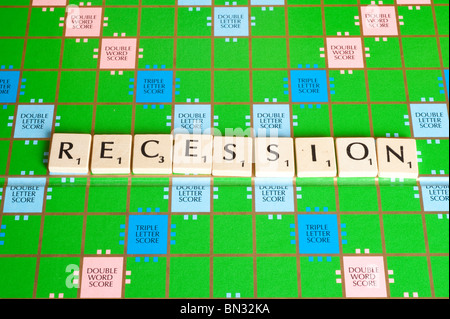 Scrabble board showing word RECESSION horizontally. Stock Photo