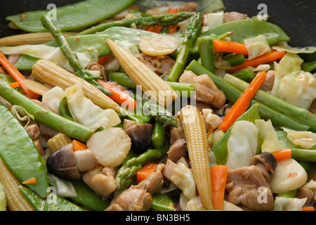 Chinese vegetable and chicken stir fry in wok close-up Stock Photo