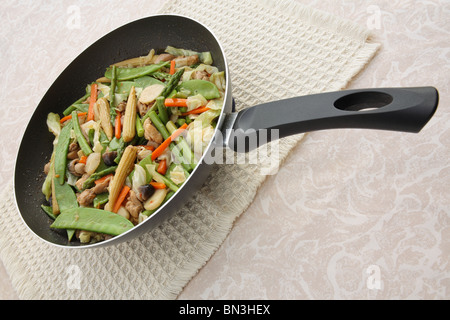 Chinese vegetable stir fry in wok on a table Stock Photo