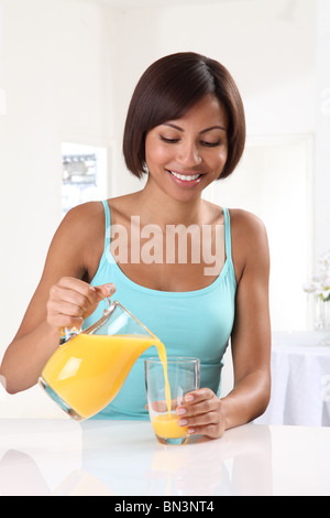 WOMAN POURING ORANGE JUICE Stock Photo