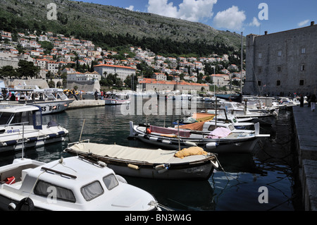 Boats moored alongside the quay in the shadow of St John's Fort in the old port of Dubrovnik Stock Photo