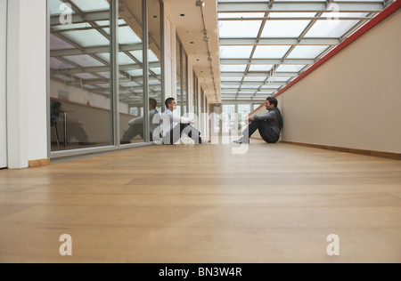 Two business men sitting on floor Stock Photo