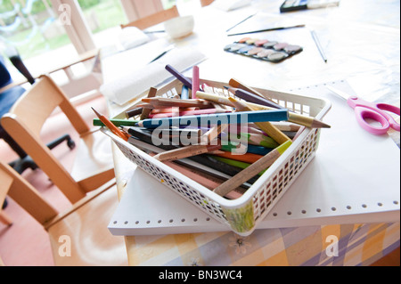 Coloured pencils in a basket on a table, elevated view Stock Photo