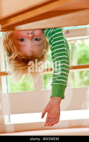 Young boy hanging upside down, low angle view Stock Photo