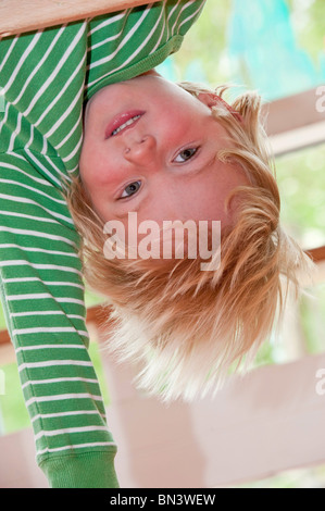 Young boy hanging upside down, low angle view Stock Photo