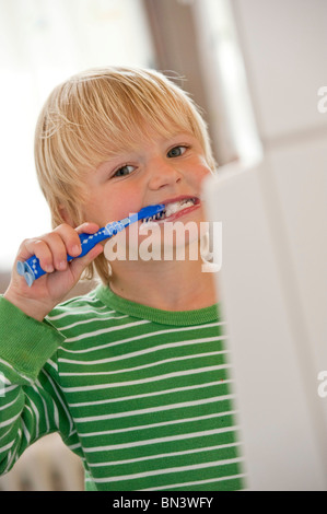 Young boy brushing his teeth, low angle view Stock Photo