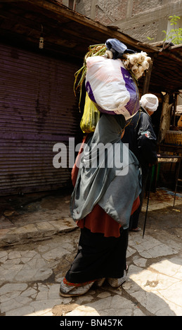 lady carrying street butchers near souk goma (friday market),  Southern Cemeteries, Khalifa district ,cairo,egypt Stock Photo