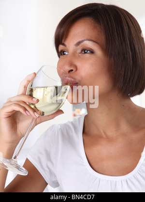 WOMAN DRINKING A GLASS OF WHITE WINE Stock Photo