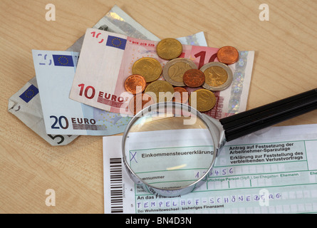 Income tax return under a magnifying glass. Stock Photo