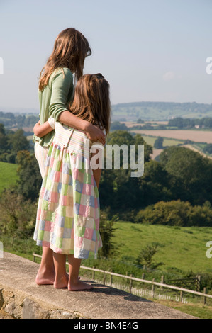 Two girls with their arms around each other Stock Photo - Alamy