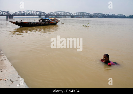 People bathing ; Dakshineshwar Hooghly river Bridge ; Calcutta Kolkata ; West Bengal ; India Stock Photo