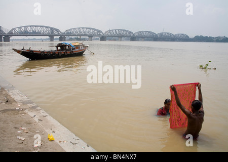 People bathing ; Dakshineshwar Hooghly river Bridge ; Calcutta Kolkata ; West Bengal ; India Stock Photo