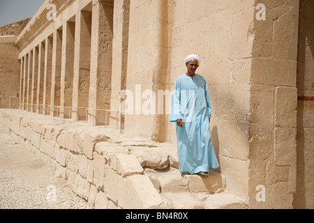 An egyptian man in a blue galabia walking by the columns of the mortuary temple of Hatshepsut, Luxor, Upper Egypt Stock Photo