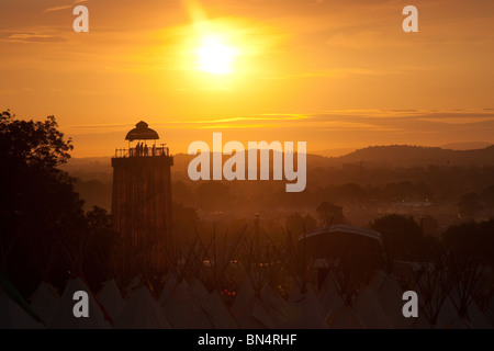 Sunset at the Glastonbury festival 2010, Photographed from Pennard Hill looking at the Park stage arena and ribbon tower Stock Photo