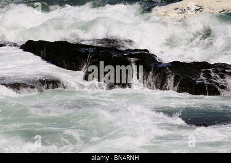 Atlantic Ocean with waves crashing over black rocks Hermanus western Cape South Africa Stock Photo