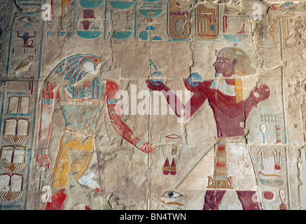 Bas relief picture from the temple of hatshepsut, Luxor, Egypt, the pharaoh (on the right) making offerings to the God Horus Stock Photo