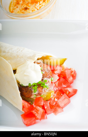 fresh traditional falafel wrap on pita bread with fresh chopped tomatoes Stock Photo