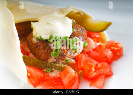 fresh traditional falafel wrap on pita bread with fresh chopped tomatoes Stock Photo