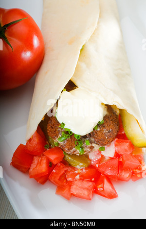 fresh traditional falafel wrap on pita bread with fresh chopped tomatoes Stock Photo