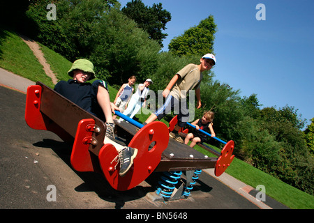 England, Cheshire, Stockport, Cheadle, Bruntwood Park, award-winning children's play area, playing on sprung see-saw Stock Photo