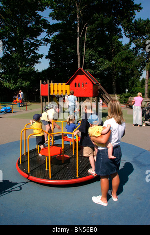 England, Cheshire, Stockport, Cheadle, Bruntwood Park, award-winning children's play area, children playing on roundabout Stock Photo