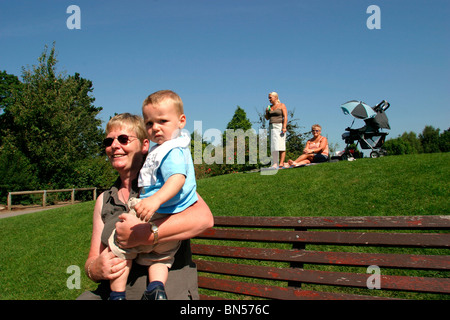 England, Cheshire, Stockport, Cheadle, Bruntwood Park, award-winning children's play area, parents watching children play in sun Stock Photo