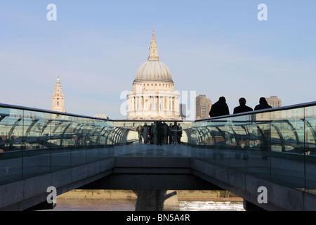 Millenium Bridge and St Paul's Cathedral from South Bank with three figures silhouetted to right hand side, London, England, UK Stock Photo