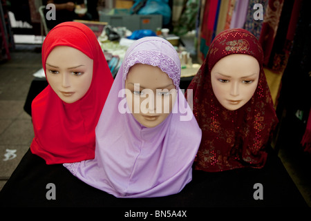 Head scarves for sale at a stall selling clothes for Muslims on Whitechapel Market in the East End of London. Stock Photo