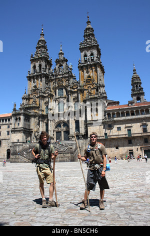 Two Pilgrims with rucksacks and staffs standing in front of the Cathedral, Santiago de Compostella, Galicia, Northern Spain. Stock Photo