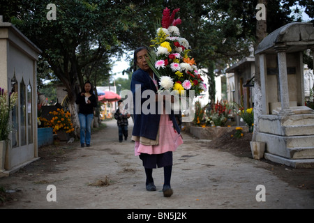A woman carries flowers in a cemetery in San Gregorio Atlapulco on the outskirts of Mexico City Stock Photo