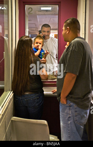 A prisoner talks with family members using a telephone at the Santa Ana, CA, city jail.  Cell block in background. MODEL RELEASE Stock Photo