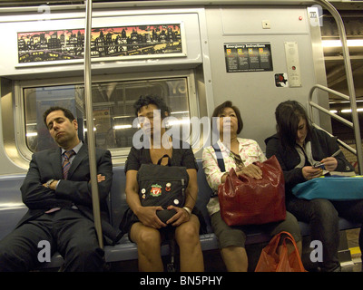 Tired riders on their way home from work on the F Train in New York City. Stock Photo