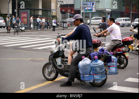 Water carrier on a motor scooter, Ningbo city, Zheijang province, China Stock Photo