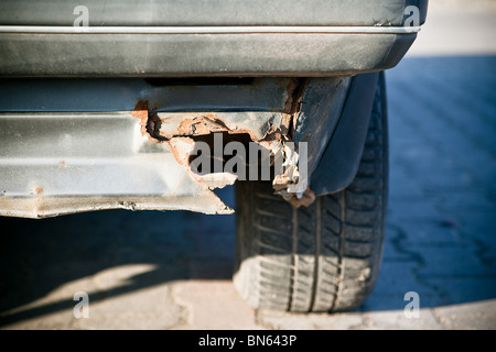 Old rusted car in junk yard - close-up to wheel and bumper Stock Photo