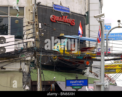 Asian passenger tricycle (widely known as tuk-tuk or tuc-tuc) mounted on the wall on Khao San Road in Bangkok, Thailand Stock Photo