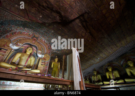 lines of buddha statues seated in a dambulla cave Stock Photo