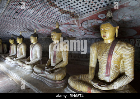 line of buddha statues seated in a dambulla cave Stock Photo