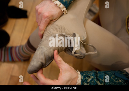 Ballet dancer puts his shoes on prior to a performance. Stock Photo