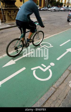 Cyclist cycles along a Spanish wheelchair / disabled person and bicycle / bike / cycle / lanes / lane in Seville, Spain.