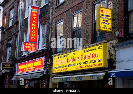 Signs above Indian restaurants / curry houses / restaurant on Brick Lane in East London. UK. Stock Photo