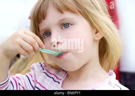 blond little girl eating ice cream color spoon portrait