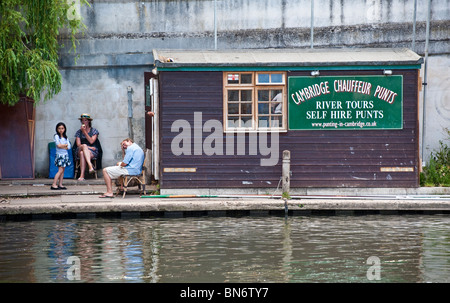 People sitting near punt hire office at the Millpond, River Cam, Cambridge, UK