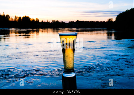 a refreshing beer in front of a scandinavian sunset Stock Photo