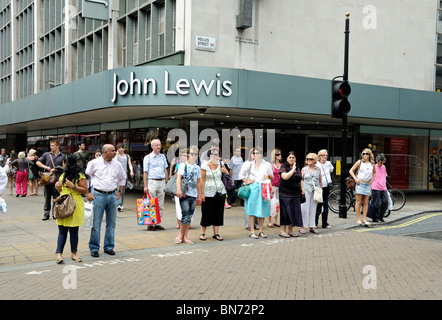 People about to cross the road in front of John Lewis department store Oxford Street London England UK Stock Photo