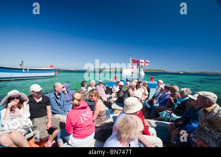 Tourists on a small passenger boat from Tresco to St Mary's on the Isles of Scilly, UK. Stock Photo