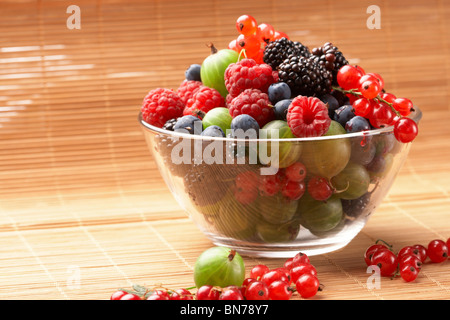 Fruit mix in the glass container, on a table from straw Stock Photo