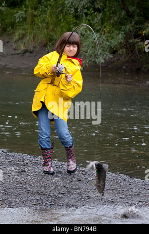 Young girl spin fishing on Ingram Creek reels in a Pink Salmon, Alaska Stock Photo